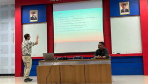 Man presenting slide in classroom lecture hall