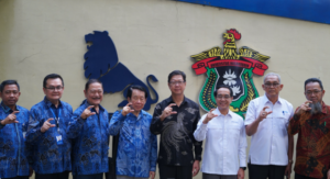 Group of men posing before lion emblem wall