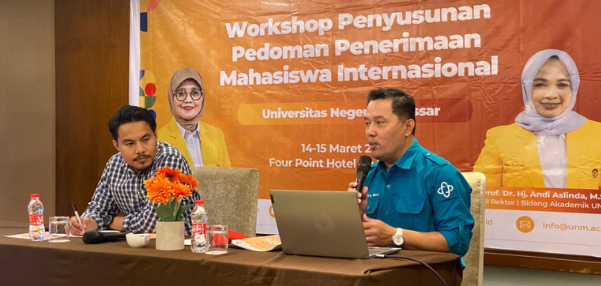 University workshop presentation with speakers and banner backdrop