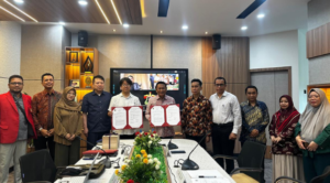 Group holding signed agreements in conference room