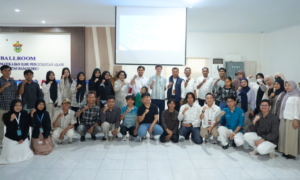 Large group posing in classroom with projector screen