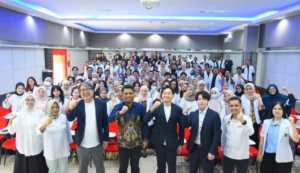 Large group posing in auditorium with raised fists