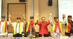 Group of men raising joined hands indoors
