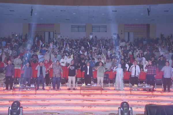 Kerumunan besar di aula mengangkat tangan bersama