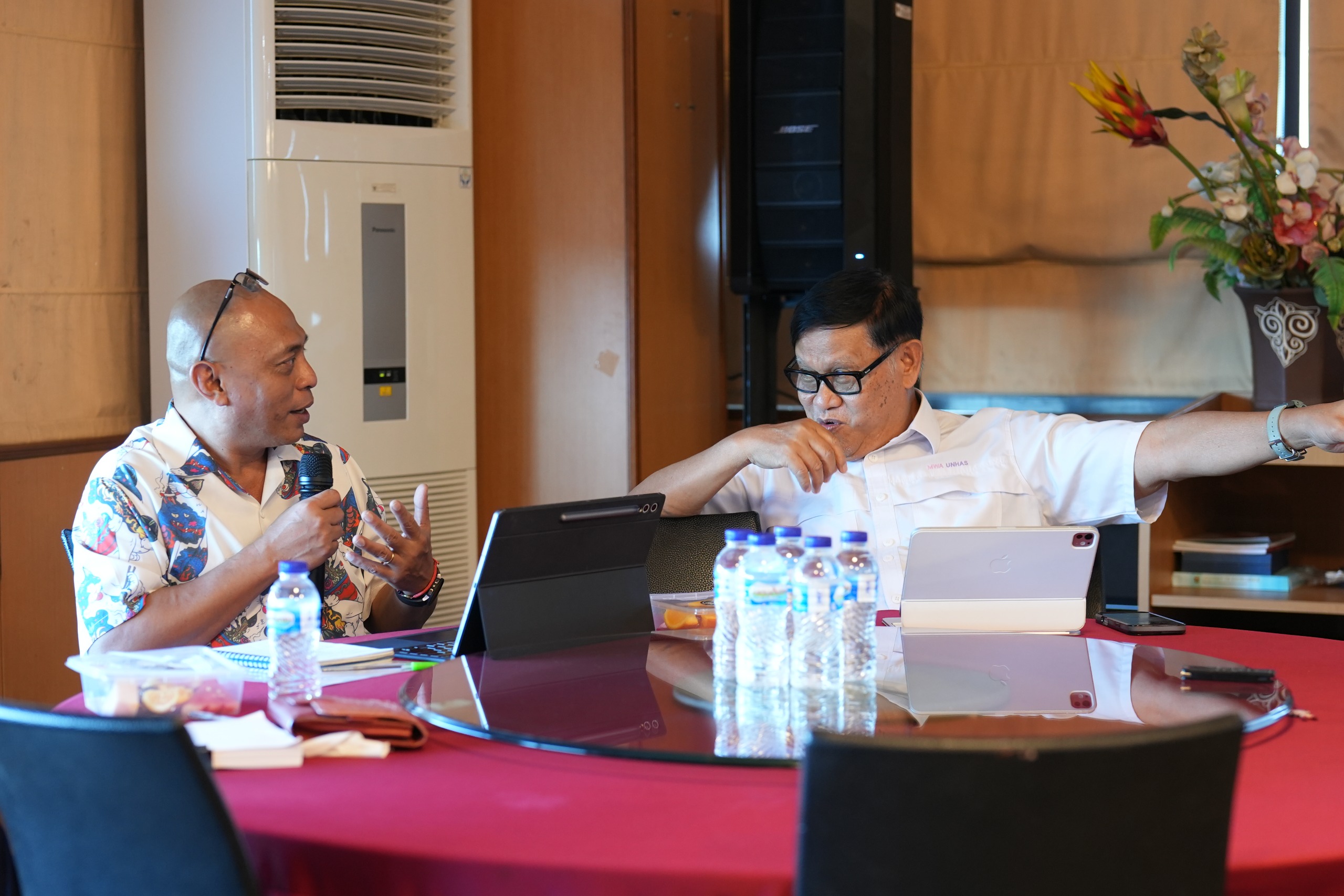 Dua pria berdiskusi di ruang rapat