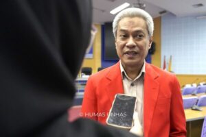 Pria berjas merah diwawancarai di ruangan