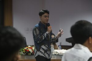 Pria berbicara dengan mikrofon di seminar