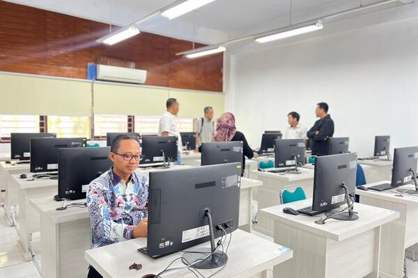 Pria bekerja di laboratorium komputer modern