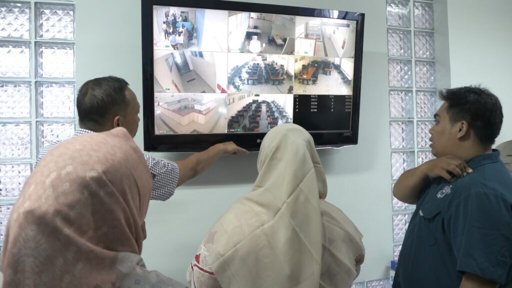 Tiga orang memantau layar CCTV di ruangan