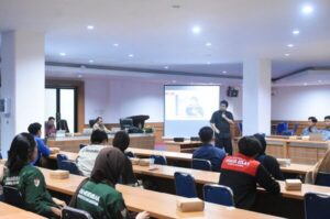 Pembicara mempresentasikan materi di ruang seminar