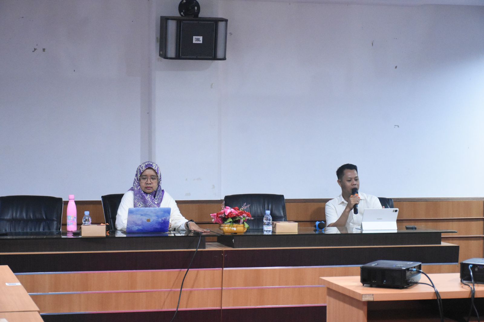 Dua pembicara dalam rapat di ruang konferensi