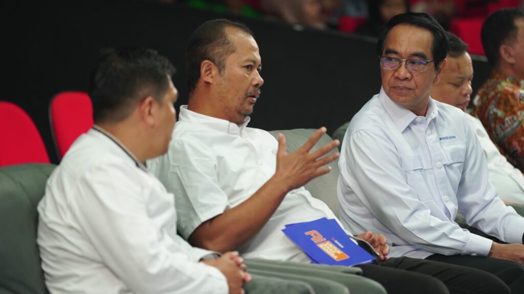 Diskusi serius pria berseragam putih di auditorium