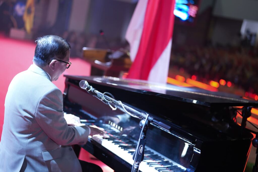 Pria memainkan piano di panggung acara