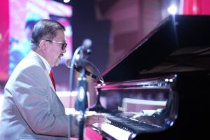 Pria bermain piano dan bernyanyi di panggung