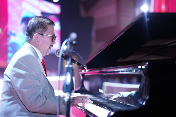 Pria bermain piano dan bernyanyi di panggung