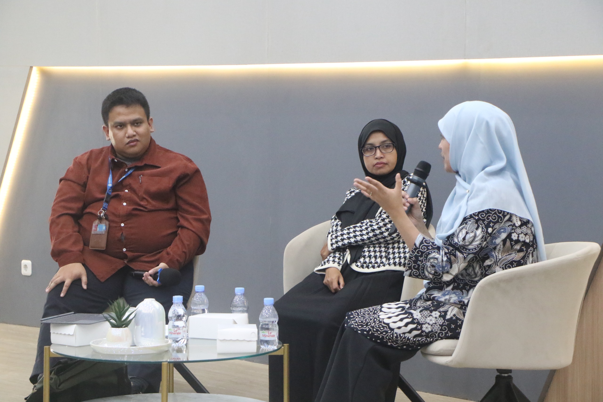 Diskusi panel dengan tiga pembicara di ruangan modern