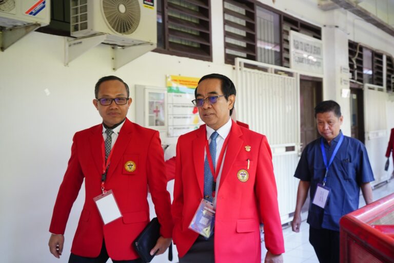 Dua pria berseragam jas merah berjalan