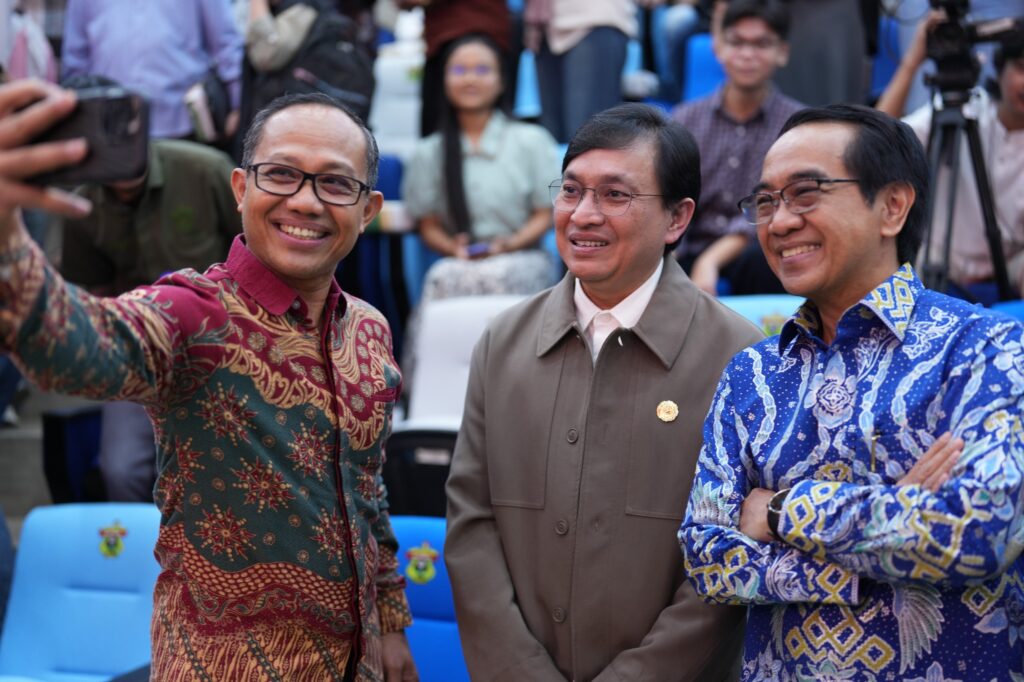 Tiga pria berswafoto di acara resmi