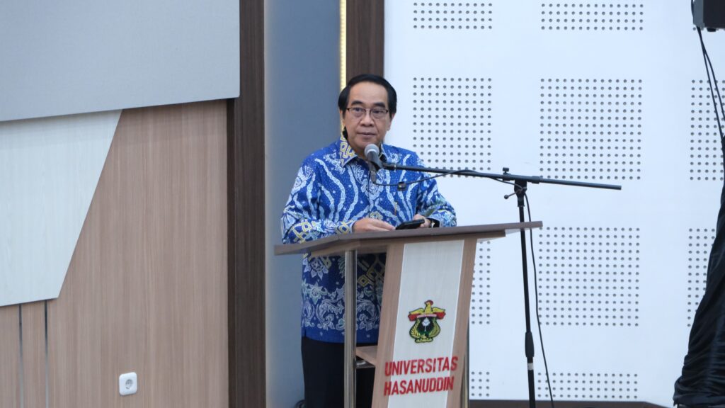 Pria berbatik berbicara di podium universitas