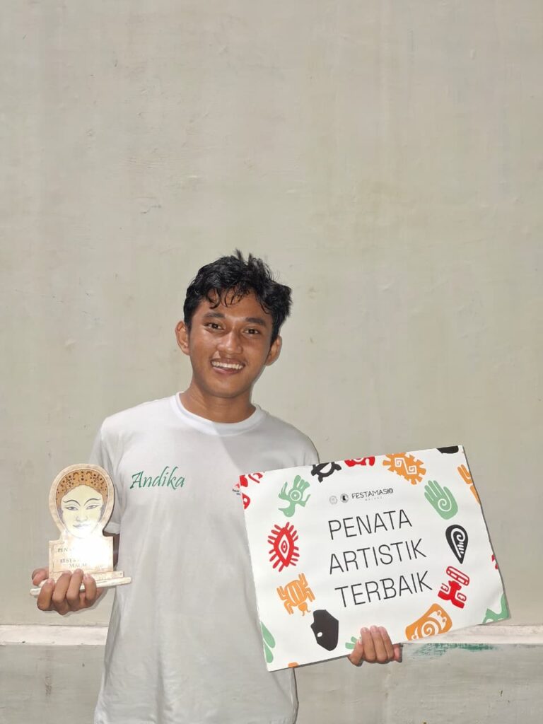 Pria memegang piala dan papan penghargaan
