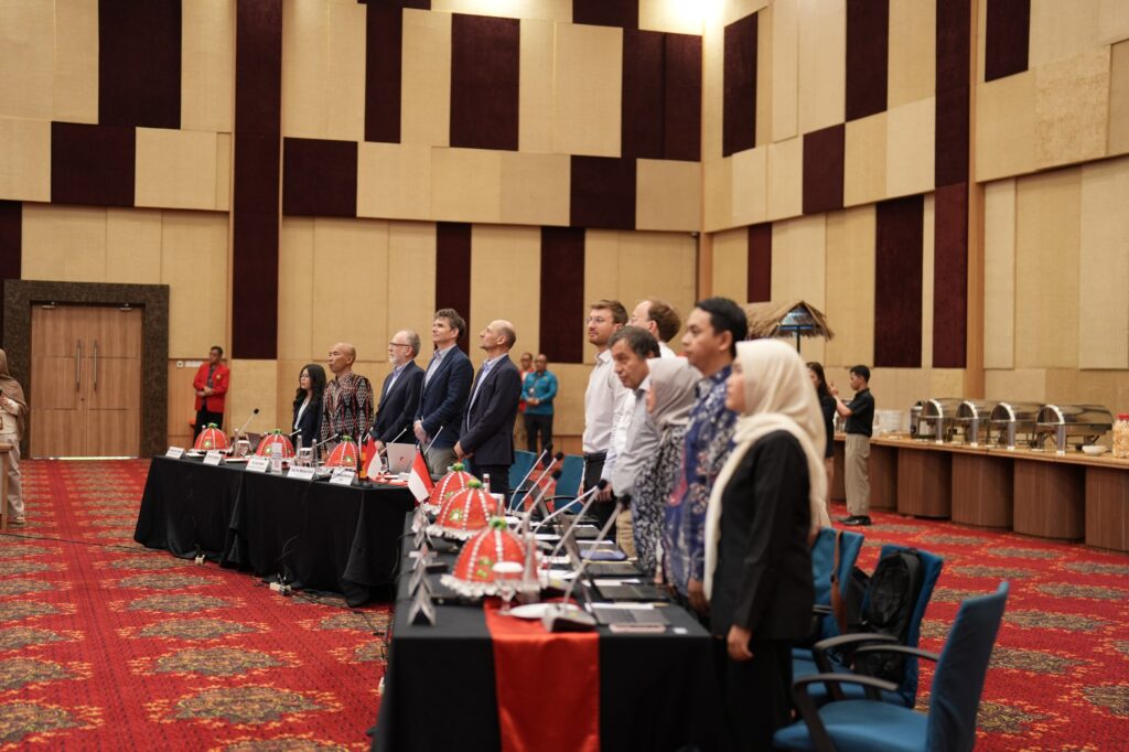 Peserta konferensi berdiri di ruang pertemuan resmi