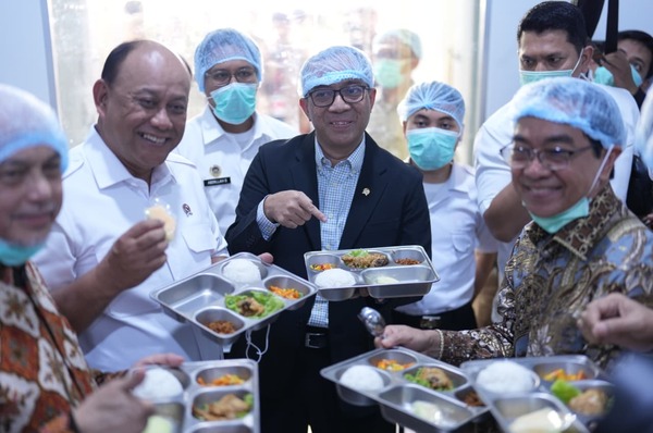 Pejabat meninjau makanan di fasilitas produksi