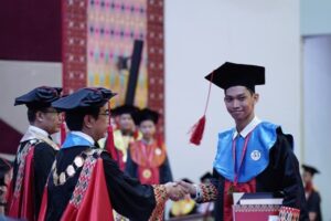 Mahasiswa wisuda berjabat tangan dengan rektor