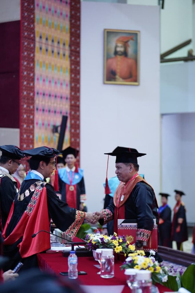 Pejabat akademik berjabat tangan saat wisuda
