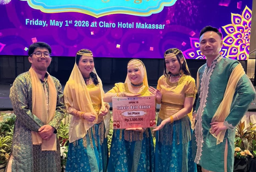 Group in traditional attire holding dance competition award