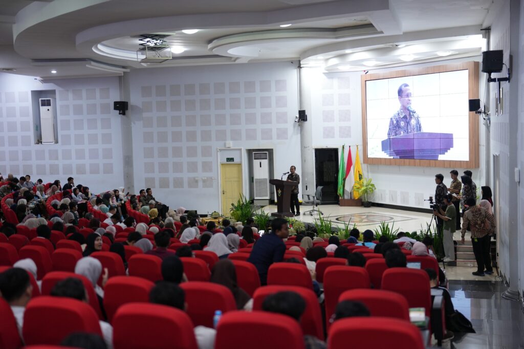 Pembicara berpidato di auditorium penuh hadirin