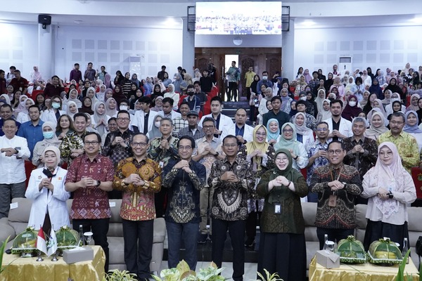 Kelompok besar berfoto di auditorium kampus