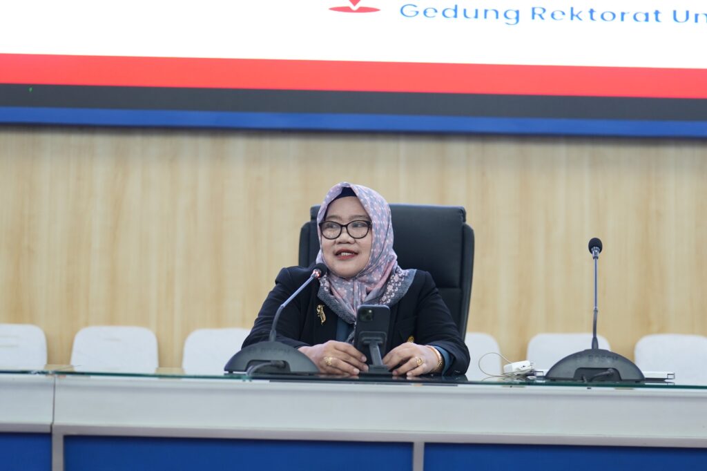 Perempuan berhijab berbicara di ruang rapat resmi