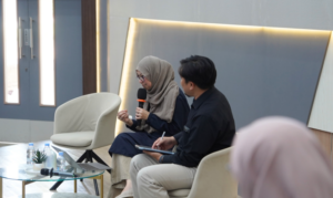 Woman speaking into microphone during panel discussion