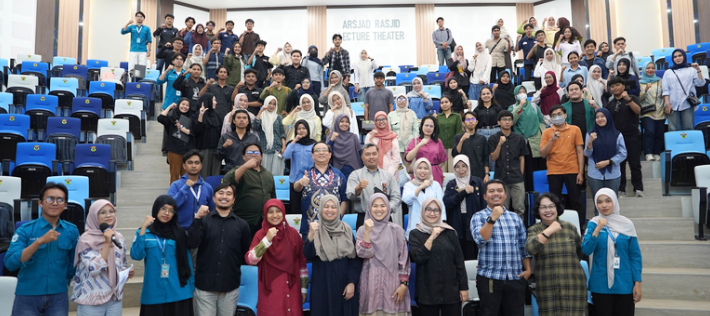 Large group posing in university lecture hall