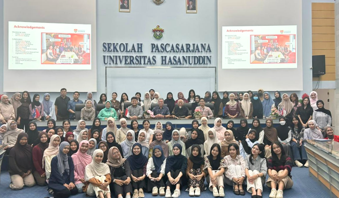 Large group photo at university auditorium stage