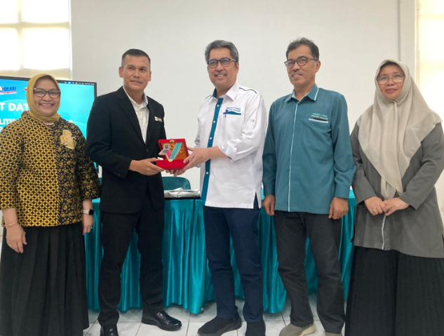 Five people presenting award plaque indoors