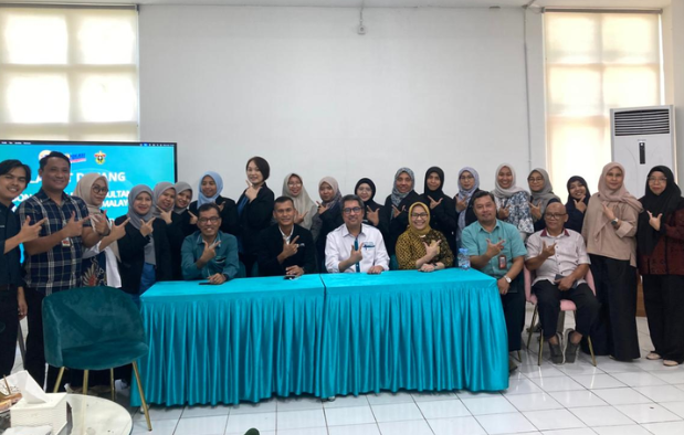 Group posing behind turquoise-covered table indoors