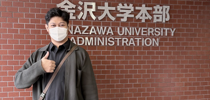 Masked person giving thumbs up at Kanazawa University