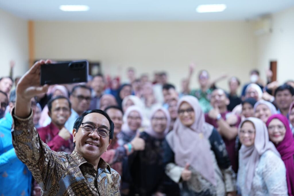 Pria berswafoto bersama kerumunan di dalam ruangan