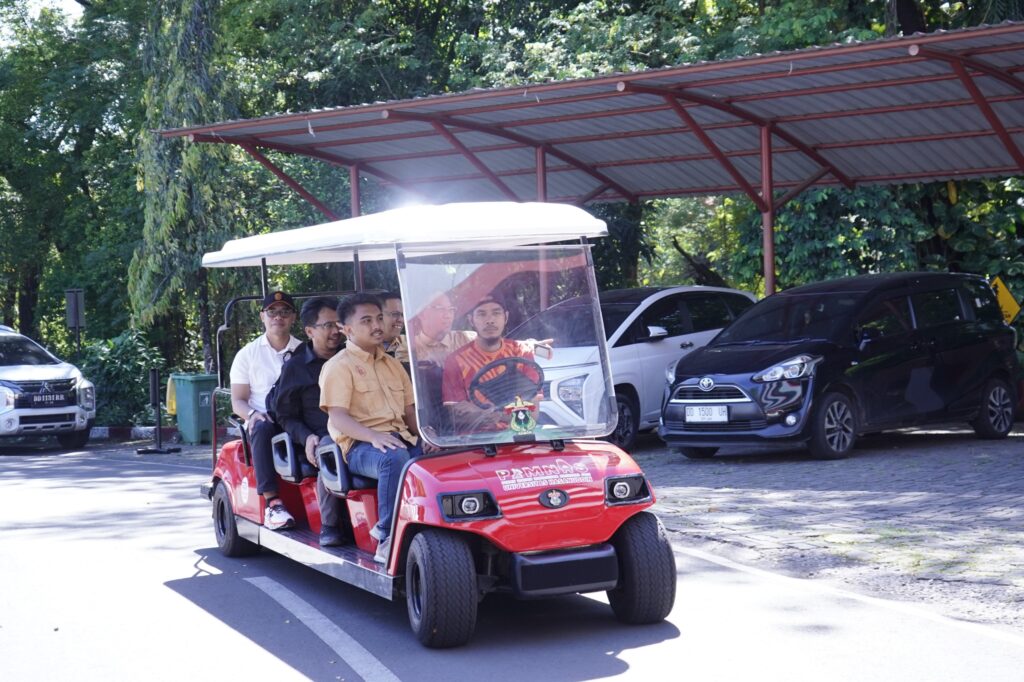 Beberapa pria menaiki mobil golf merah