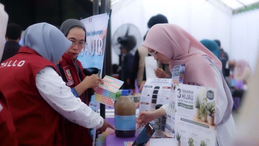 Perempuan berhijab berdiskusi di stan edukasi lingkungan