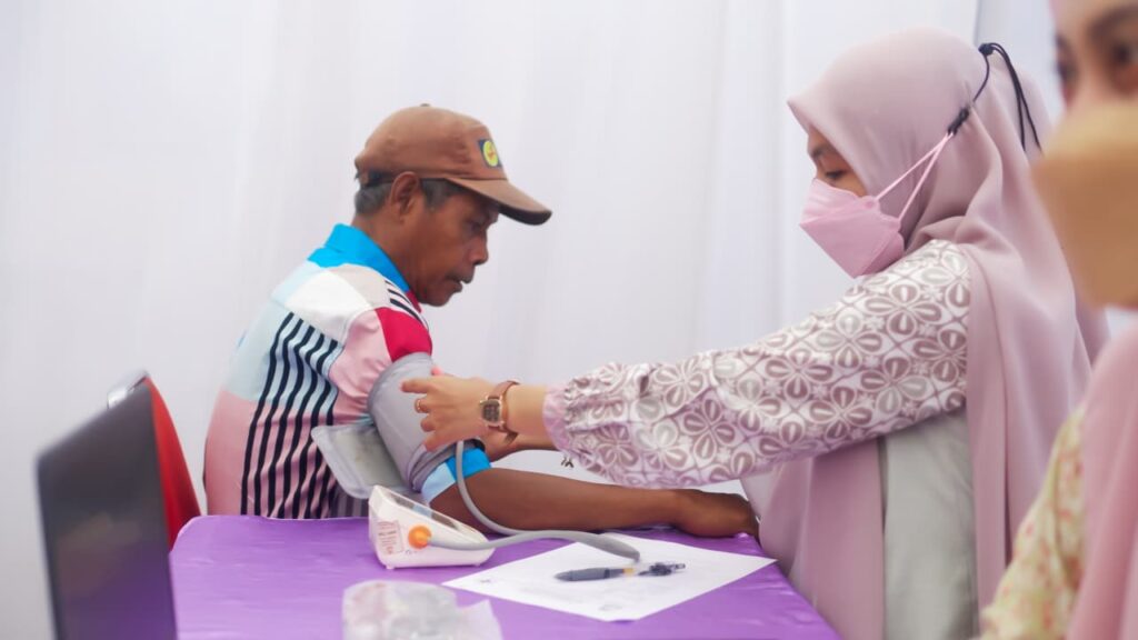 Petugas medis memeriksa tekanan darah pria