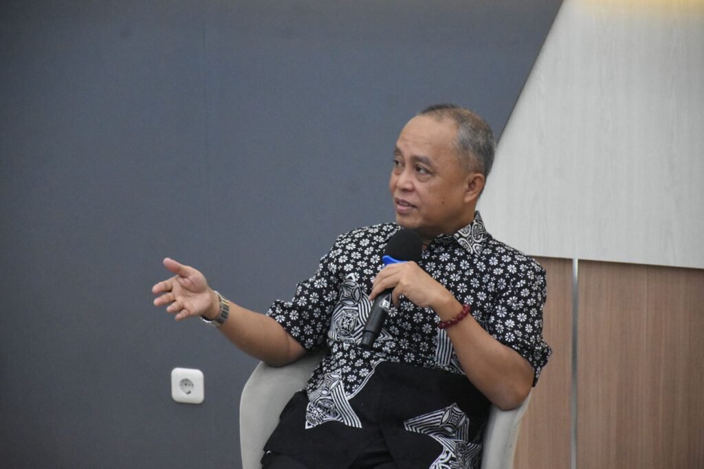 Pria berbaju batik berbicara memegang mikrofon
