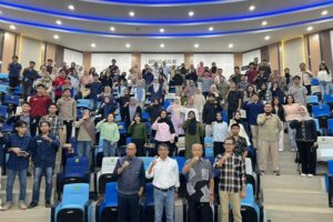 Peserta acara berfoto bersama di auditorium kampus