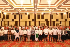 Kelompok besar berfoto di aula konferensi