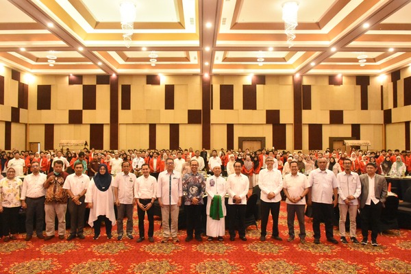 Kelompok besar berfoto di aula konferensi