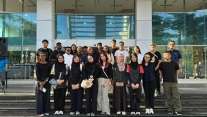 Group of young adults posing outside modern building
