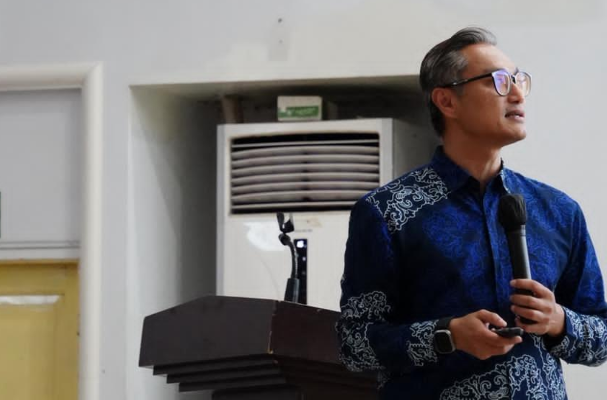 Man giving presentation holding microphone indoors