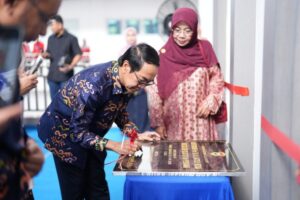 Man signing commemorative plaque at ceremony