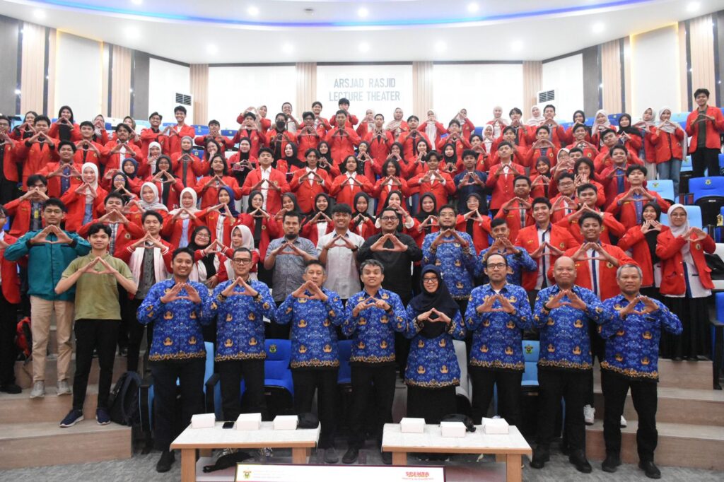 Mahasiswa dan dosen berpose di auditorium kampus